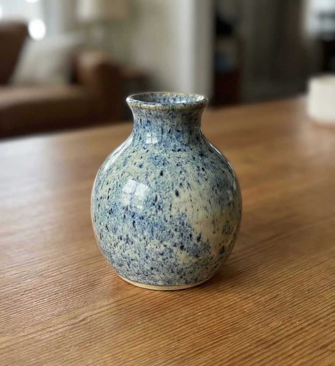 Photo of a speckled blue ceramic vase on a wooden table, used as the input image